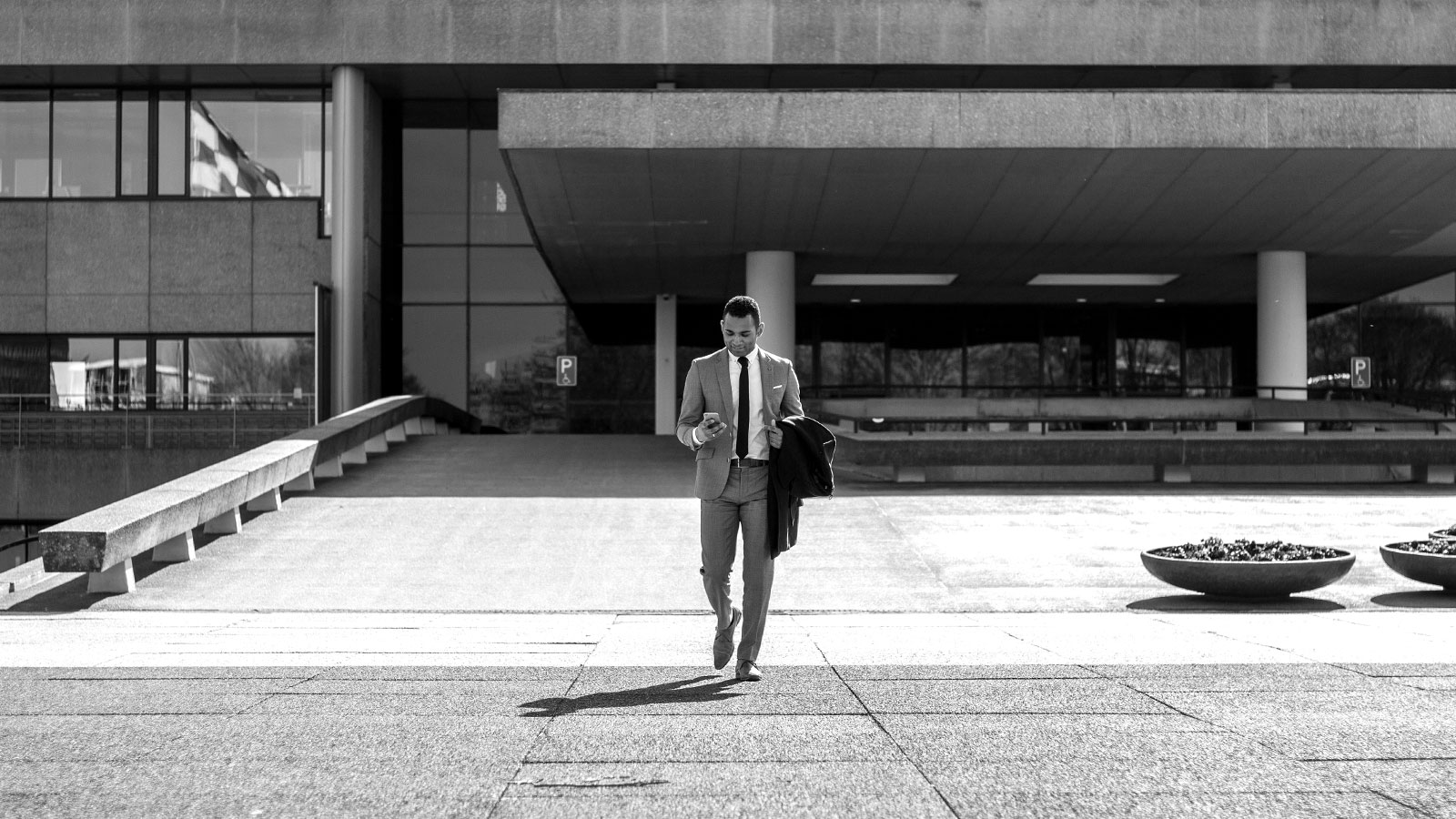 LeasePilot Brand Identity – Black & White Photography: Businessman Walking with Smartphone in City